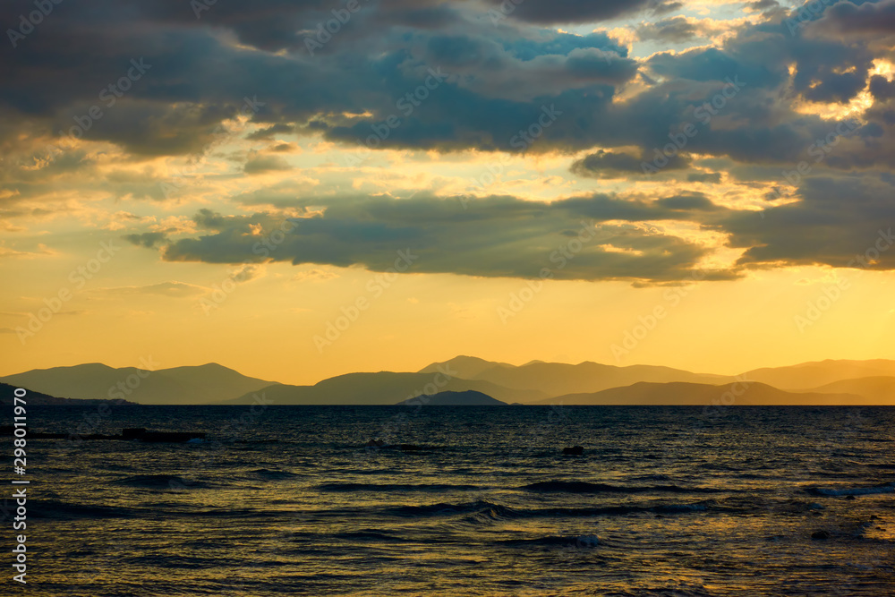 Sundown over the sea and land with mountains