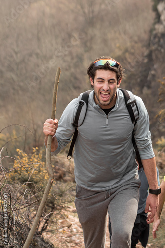 Young man enjoying the nature. Bearded man smiling. Hiker in the middle of a journey