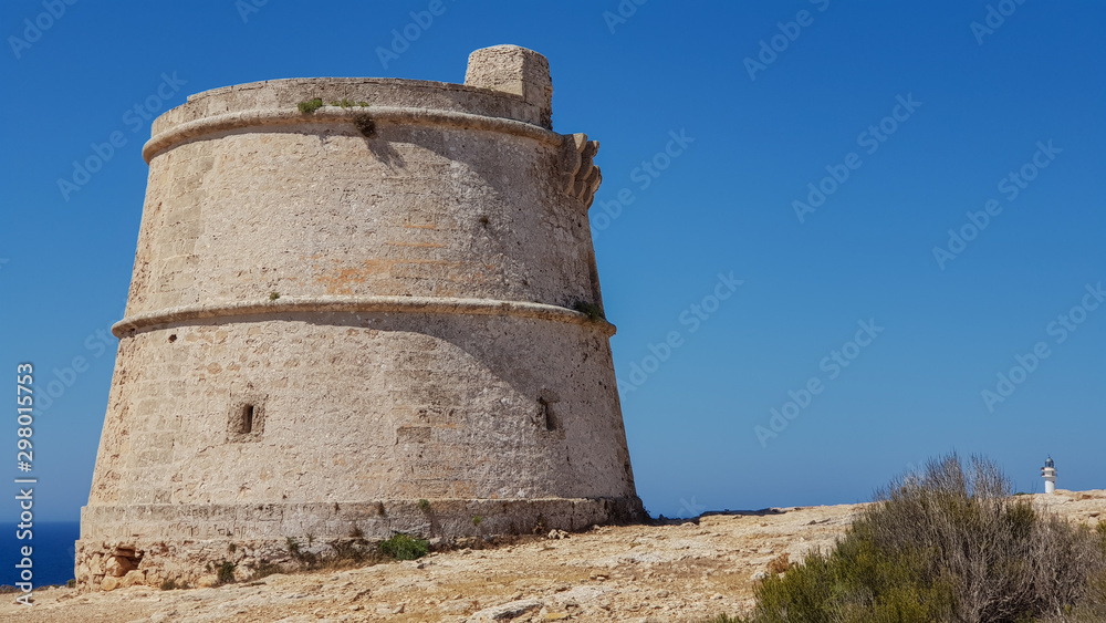 Old defense tower: Torre del cap de Barbaria, in the distance Far del cap de Barbaria, Formentera