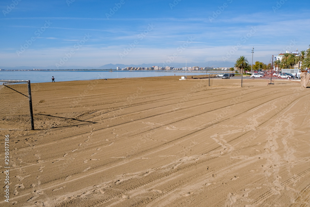 Obraz premium Playground for playing beach soccer in Roses, Catalunya, Spain. Empty beach on a sunny day on the sea and blue sky background. Traces of car tires in the sand. Preparing the beach for the game.