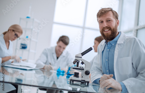 successful young scientist sitting at his Desk in the laboratory