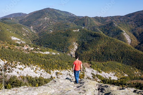 Relaxed tourist admiring the view from the mountain top,hiking concept, Panoramic view landscape from mountain, Bulgaria