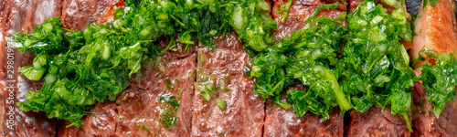 Roast sliced beef Steak medium rare Striploin with chimichurri sauce close up