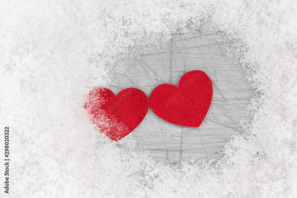 Two red hearts is laying together among snow. Relations concept
