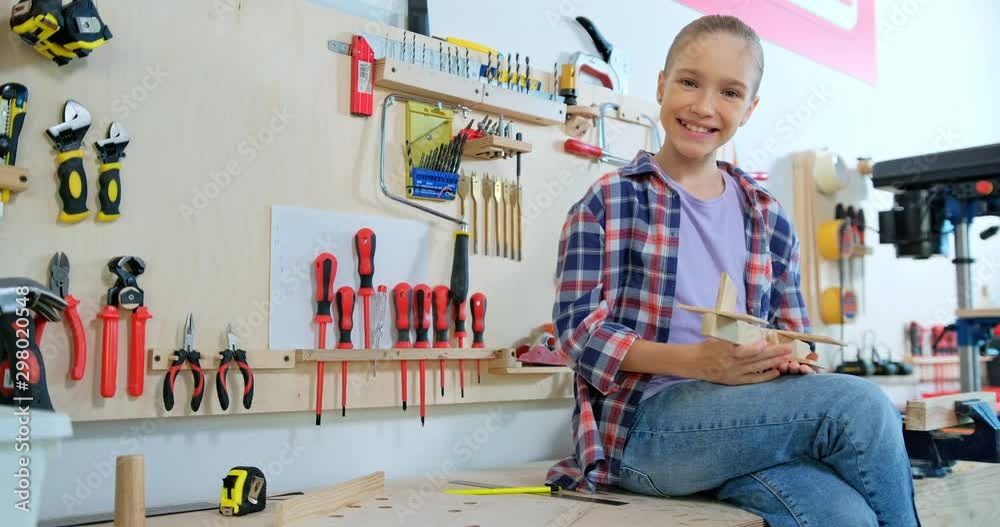 Preteen girl made aircraft model in the workshop and smiling at camera Видео Stock | Adobe Stock