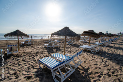 Straw umbrellas and beach loungers on Malvarrosa sand beach in Valencia © Guy