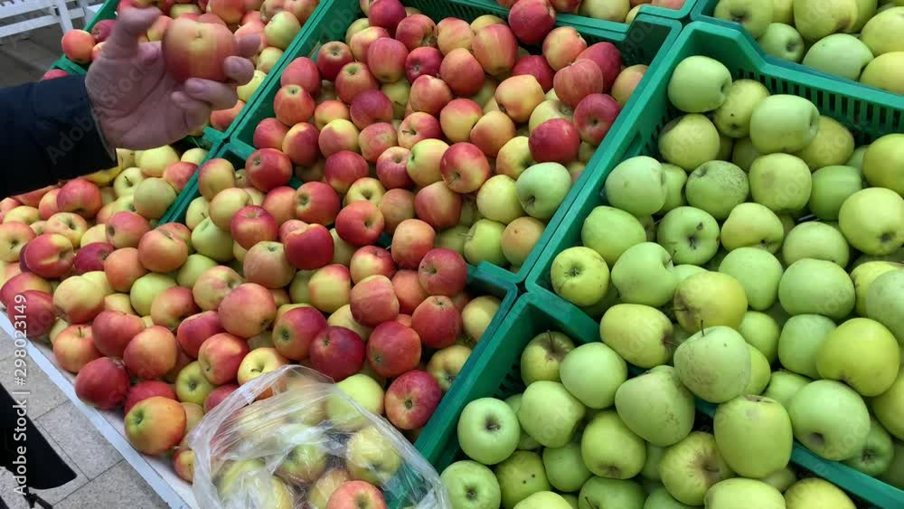 Close up, supermarket, market, grocery store slender. Man doing groceries and picking apples. Concept of healthy eating and lifestyle Close up, supermarket, market, grocery store slender. Man doing groceries and picking apples. Concept of healthy eating and lifestyle