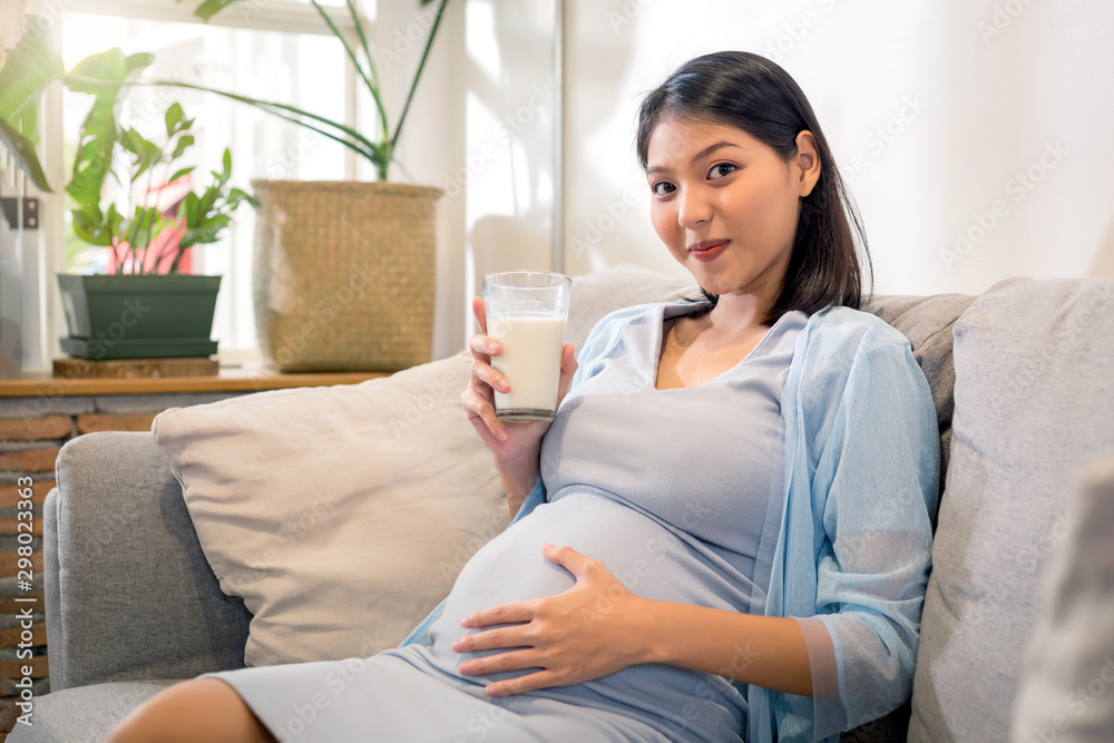 Φωτογραφία Young beauty happy Asian pregnant woman holding glass of milk drinking healthy drink