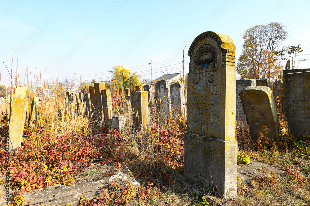 Φωτογραφία An old cluttered Jewish cemetery with uneven tombstones carved in Hebrew is a preserved story