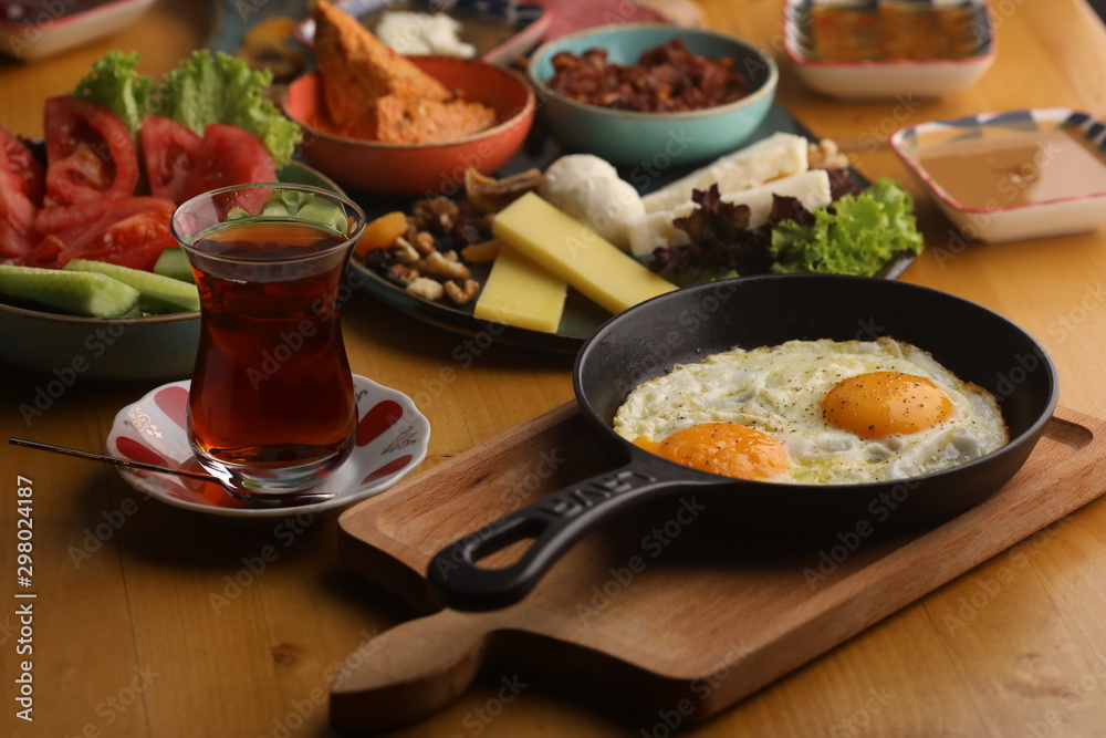 Turkish breakfast table serving with fried egg and Turkish tea