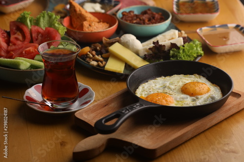 Turkish breakfast table serving with fried egg and Turkish tea