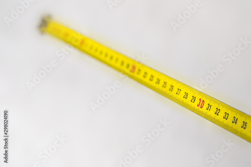 Yellow measuring tape with size 30 on white background. The concept of discounts. 