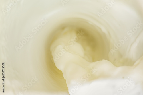 Soft white pouring stream of milk is close