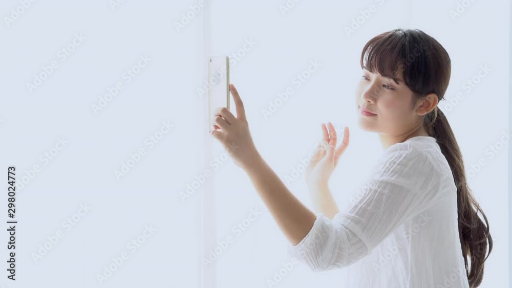 Beautiful portrait young asian woman standing taking a selfie with smart mobile phone on bedroom in the morning at home, girl is photographing happy and smile with fun, lifestyle concept, slow motion. Beautiful portrait young asian woman standing taking a selfie with smart mobile phone on bedroom in the morning at home, girl is photographing happy and smile with fun, lifestyle concept, slow motion.