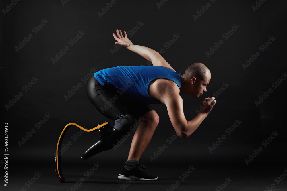 Αυτοκόλλητο Side view of paralympic sportsman in sports clothing and with prosthesis instead