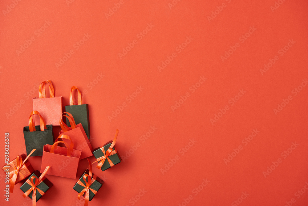 top view of gift boxes and shopping bags on red background with copy space