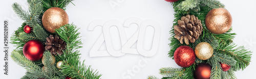 top view of 2020 numbers in Christmas tree wreath on white background  panoramic shot