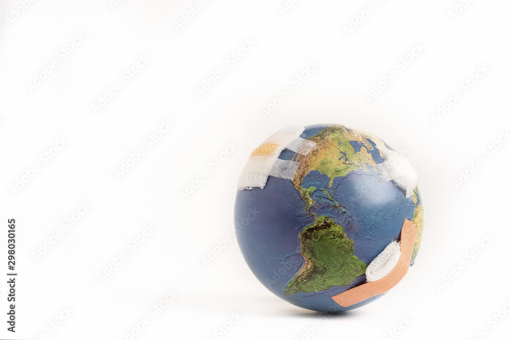 Closeup of a beautiful globe full of bandages as a symbolic of world environmental problem air pollution, waste disposal, fossil fuels which damaged earth and cause global warming. Isolated on white. Closeup of a beautiful globe full of bandages as a symbolic of world environmental problem air pollution, waste disposal, fossil fuels which damaged earth and cause global warming. Isolated on white.