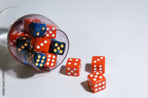 Red and blue dice in a glass. Many dice of different colors in a glass glass. Copyspace