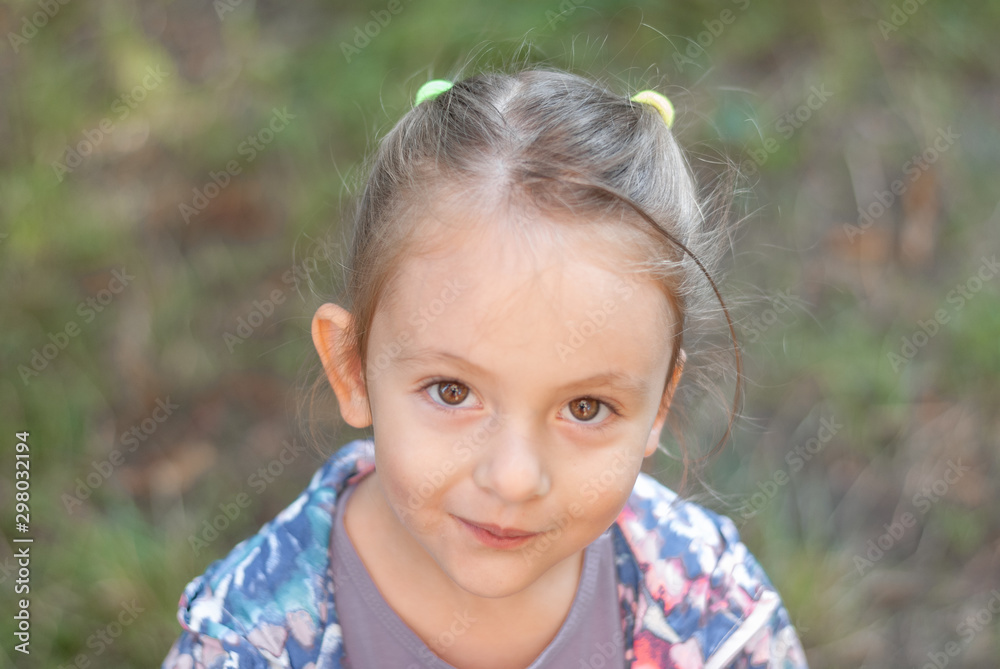 Smiling serene little girl staring at the camera. Smiling serene little girl staring at the camera.