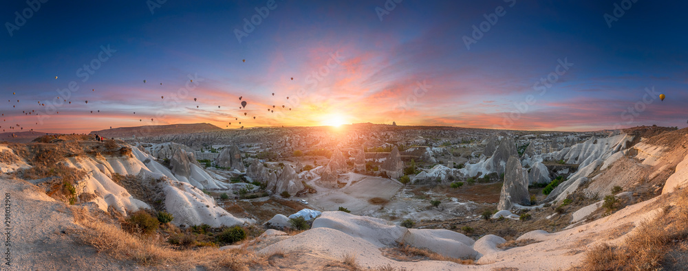 Beautiful scenes in Goreme national park. Hundreds of colorful hot air balloons flying in the sky on sunrise. Incredible rock formations in the valley Cappadocia, Turkey