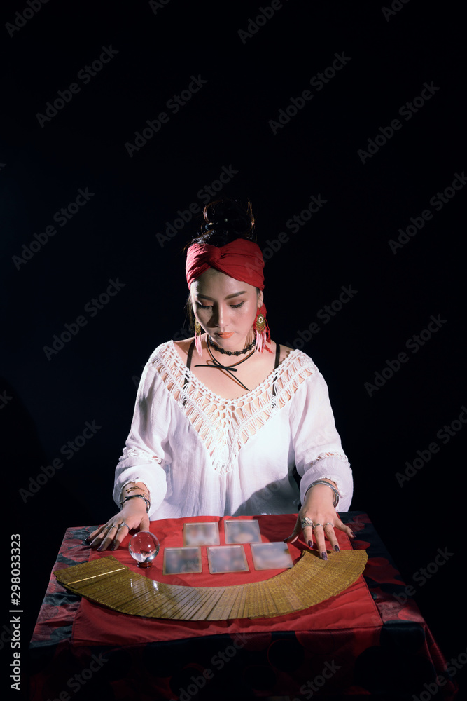 Fototapeta premium Tarot Cards Fortune teller woman hands doing magical to predicting the past and future in the dark room