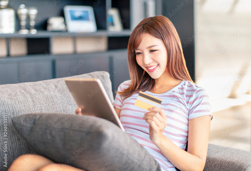 Obraz premium smiling young woman shopping online with credit card