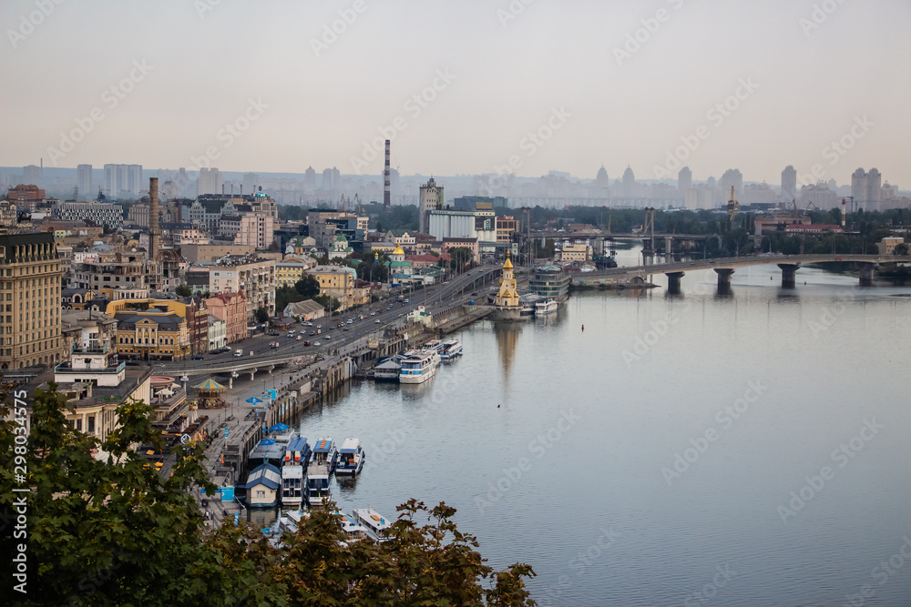 Obraz premium Tour of Kiev in the center of Europe. View of the Dnieper, Trukhanov island and a foot bridge. Park fountain and sunset on the horizon..
