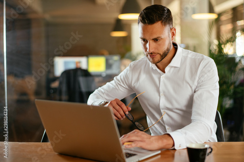 Young businessman using laptop in his office