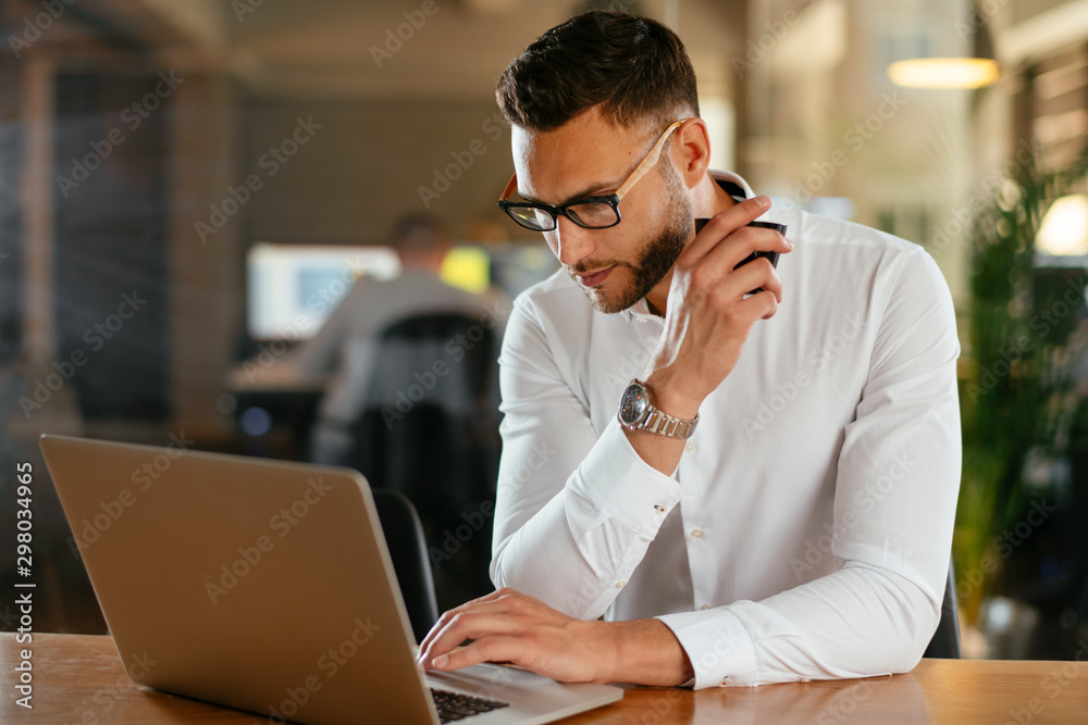 Businessman using laptop and drinking coffee Businessman using laptop and drinking coffee