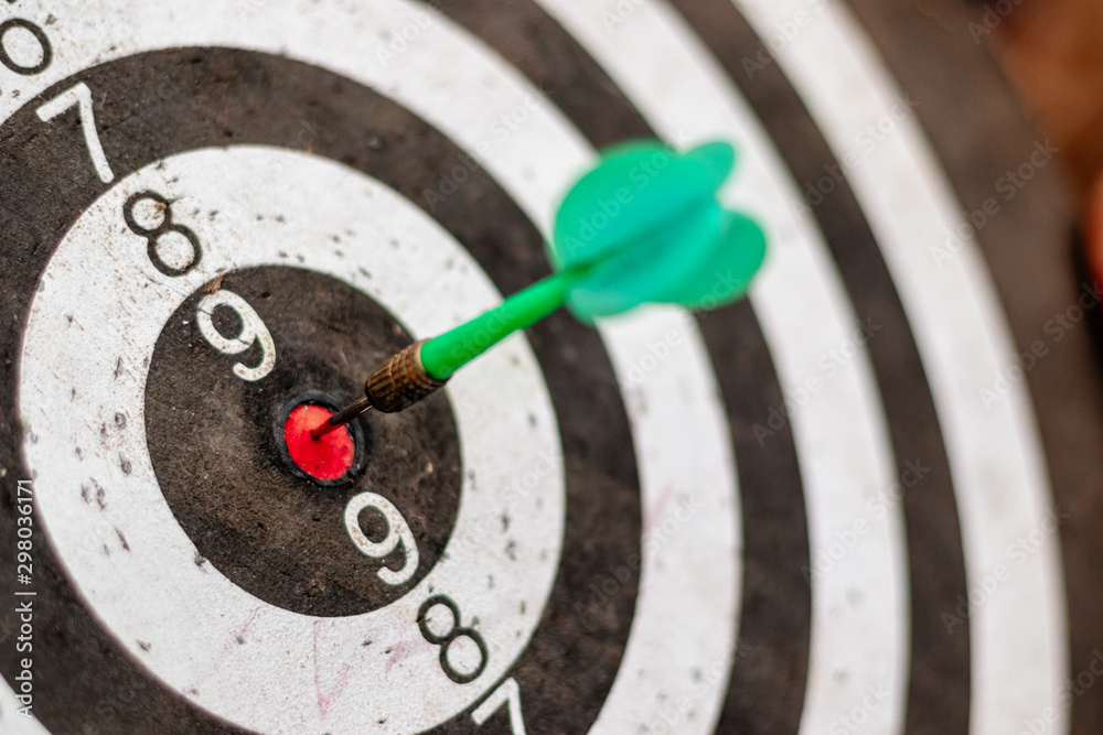 Green arrow in the center of the dart board Shows the concept of business goal setting. Green arrow in the center of the dart board Shows the concept of business goal setting.