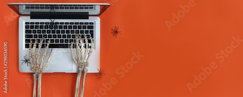 Skeleton hands typing on laptop