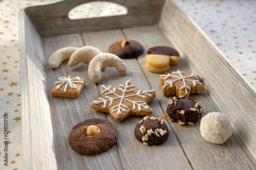 Group various kinds of delicious sweet Christmas cookies on light gray wood, tasty holiday breakfast