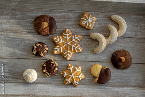 Group various kinds of delicious sweet Christmas cookies on light gray wood, tasty holiday breakfast
