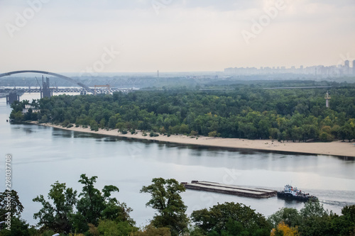 Tour of Kiev in the center of Europe. View of the Dnieper, Trukhanov island and a foot bridge. Park fountain and sunset on the horizon..