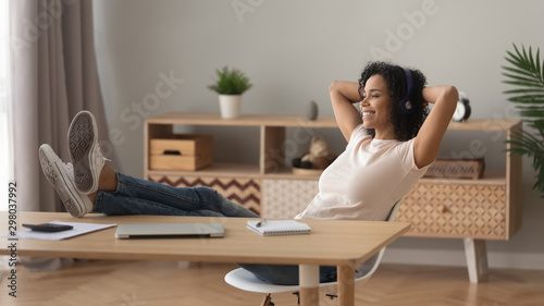 Slika na platnu Smiling biracial girl relaxing at home listening to music