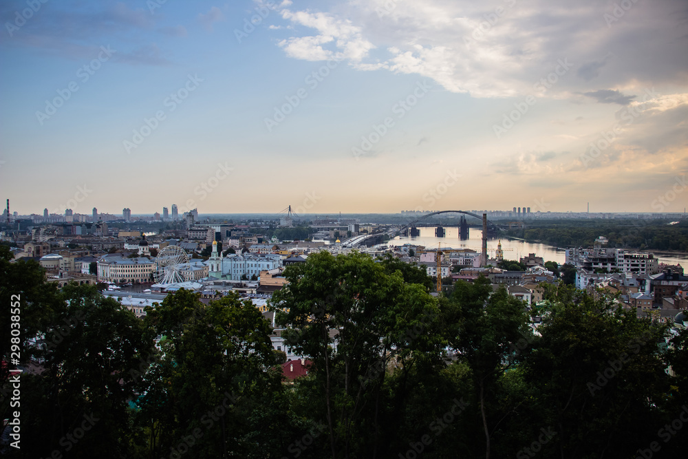 Tour of Kiev in the center of Europe. View of the Dnieper, Trukhanov island and a foot bridge. Park fountain and sunset on the horizon..