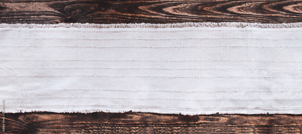 Grey fabric runner on an old wooden rustic table background with copy space. Top view. - obrazy, fototapety, plakaty 