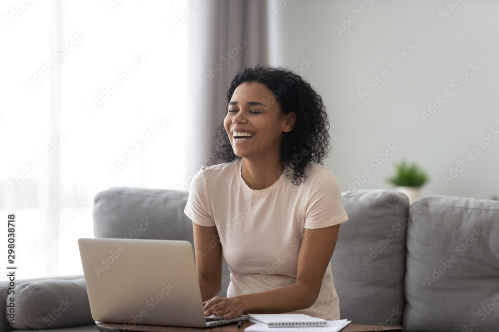 Happy black woman laughing using laptop typing Happy black woman laughing using laptop typing
