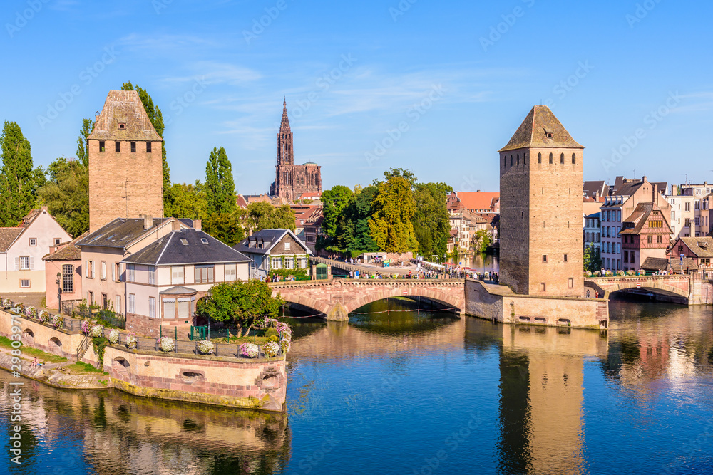 The Ponts Couverts, a medieval set of bridges and towers on the river Ill at the entrance of the Petite France historic quarter in Strasbourg, France, and Notre-Dame cathedral in the distance.