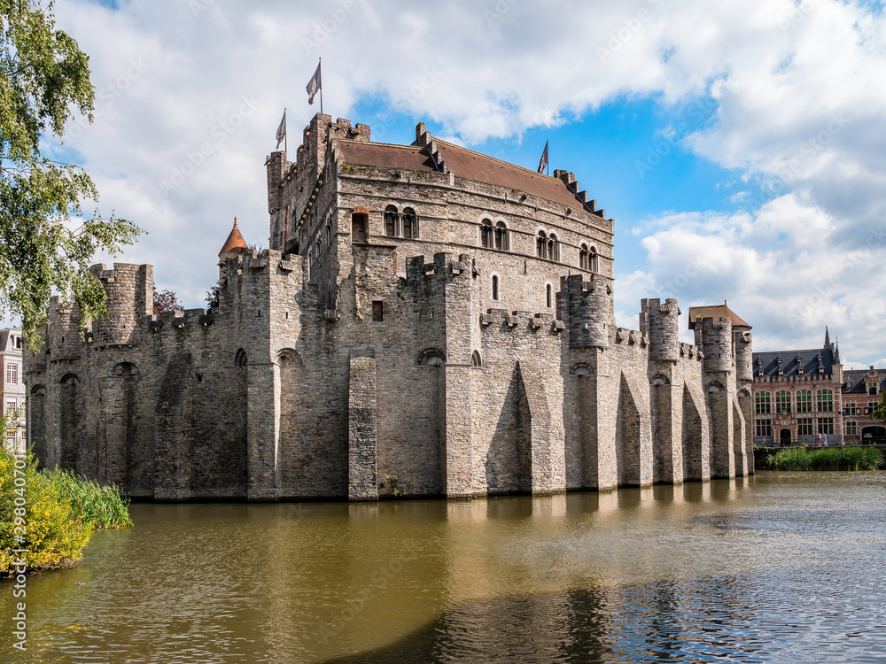 Castle of the Counts next to river Lys in Ghent, Belgium. Famous fortress in Gent old town. Beautiful architecture and landmarks of the medieval city on a sunny day.