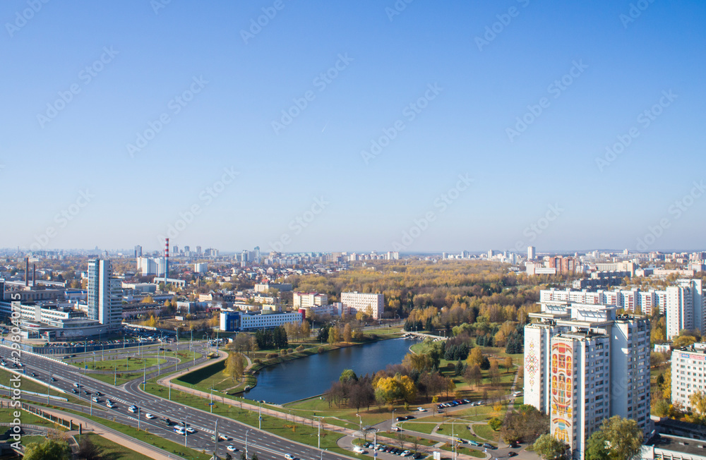 Fototapeta premium City architectural landscape Minsk. Office buildings of the road and parks. View from the roof with blue sky.