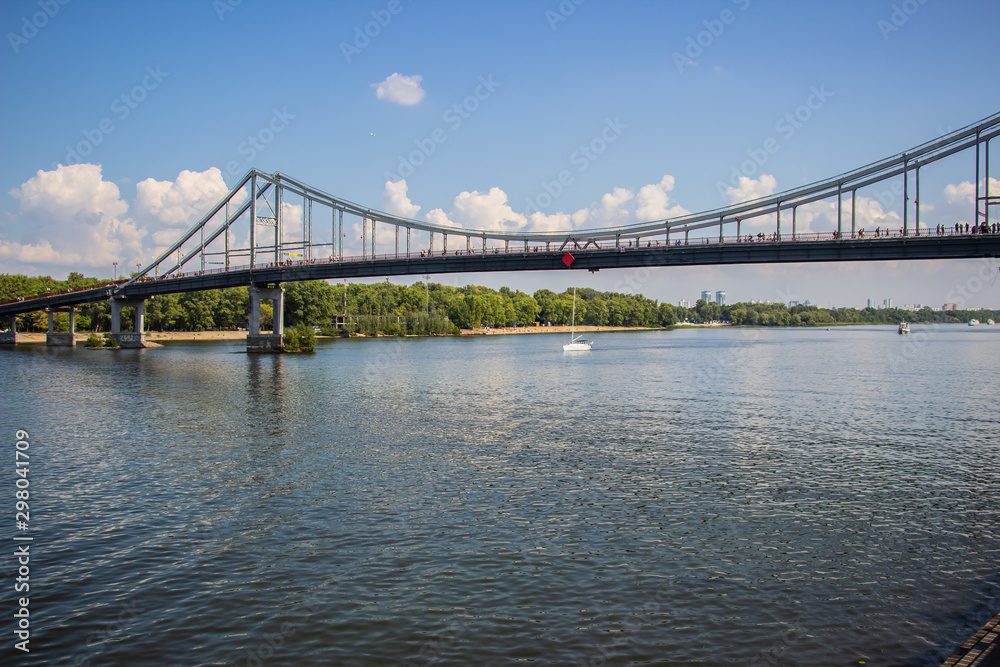 Tour of Kiev in the center of Europe. View of the Dnieper, Trukhanov island and a foot bridge. Park fountain and sunset on the horizon..