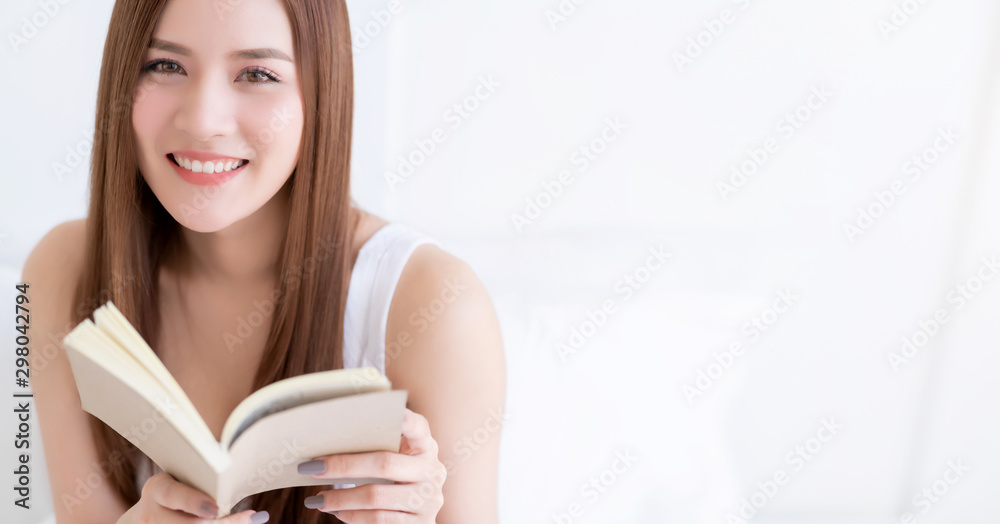 beauty asian female white dress long hair read book on white bed with clam and cheerful white bedroom interior background beauty asian female white dress long hair read book on white bed with clam and cheerful white bedroom interior background