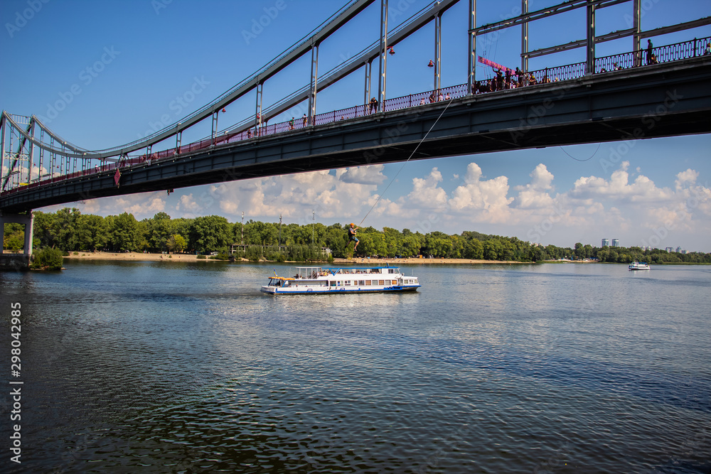 Tour of Kiev in the center of Europe. View of the Dnieper, Trukhanov island and a foot bridge. Park fountain and sunset on the horizon.. Tour of Kiev in the center of Europe. View of the Dnieper, Trukhanov island and a foot bridge. Park fountain and sunset on the horizon..