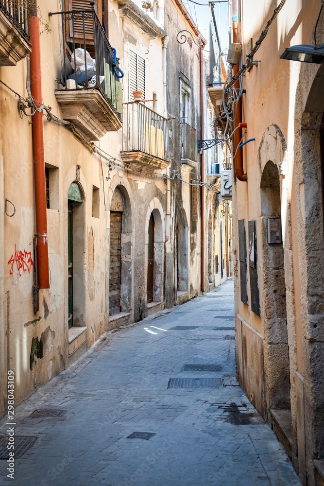 Fototapeta View of an old street in the city centre of Ortigia (part of the city of Siracusa, Italy, Sicily).