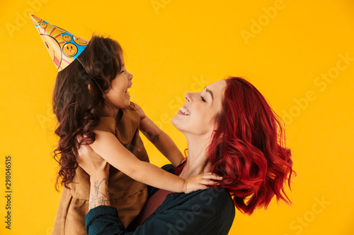 Image of caucasian happy woman lifting up her daughter in arms