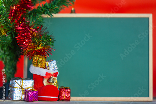 Christmas background concept. Christmas gift boxes in various colors placed in front of the green and have a red background.
