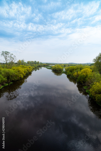 River and trees on calm day. Natural landscape