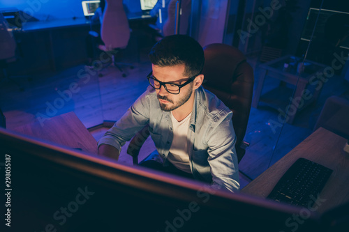 Photo of it specialist serious guy sitting chair seriously looking many monitors writing secure code for website calculate algorithms content development expert office indoors